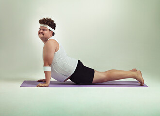 This upward facing dog pose is great. Shot of an overweight man doing yoga poses.