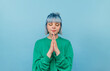 © bodnarphoto - Cute girl with colored hair with closed eyes praying on a blue background.