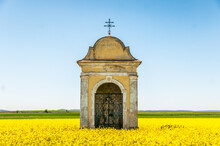 View Of A Small Chapel In A Rapeseed Field