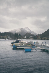 Canvas Print - Vertical shot of boats on a lake water in a mountainous place