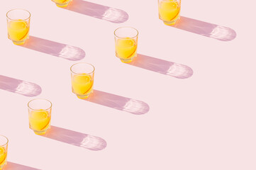 Orange juice drinks on a pastel pink background. Aesthetic juicy drink concept with diagonal copy space..