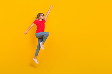 Poster - Full body profile side photo of youth active girl jump power hero look empty space isolated over yellow color background