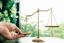 Tip The Scales Of Justice Concept As A The Hand Of A Person Illegally Influencing The Legal System For An Unfair Advantage.