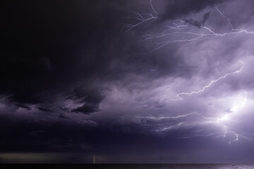 Wall Mural - Dramatic purple sunset sky with thunderstorm and lightning