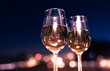 Wall Mural - two glasses of wine on blue night sky background 