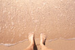 Woman's feet standing on sandy beach. Peace in nature, and seaside holiday connect 