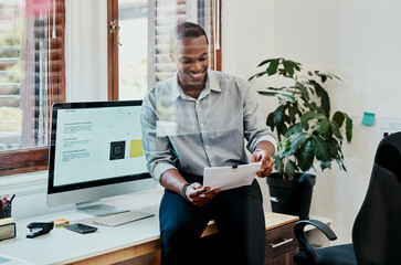Aufkleber - The results are in and they look good. Shot of a young businessman going over paperwork in a modern office.