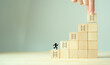 © Parradee - Strategies and success concept. Rises up stairs to goal, achieve business success. Personal growth. Initiation for planning to reach target. Take action icons on wooden cubes with grey background.