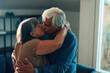 © Carlo Prearo - elderly heterosexual couple with gray hair kissing and hugging at home