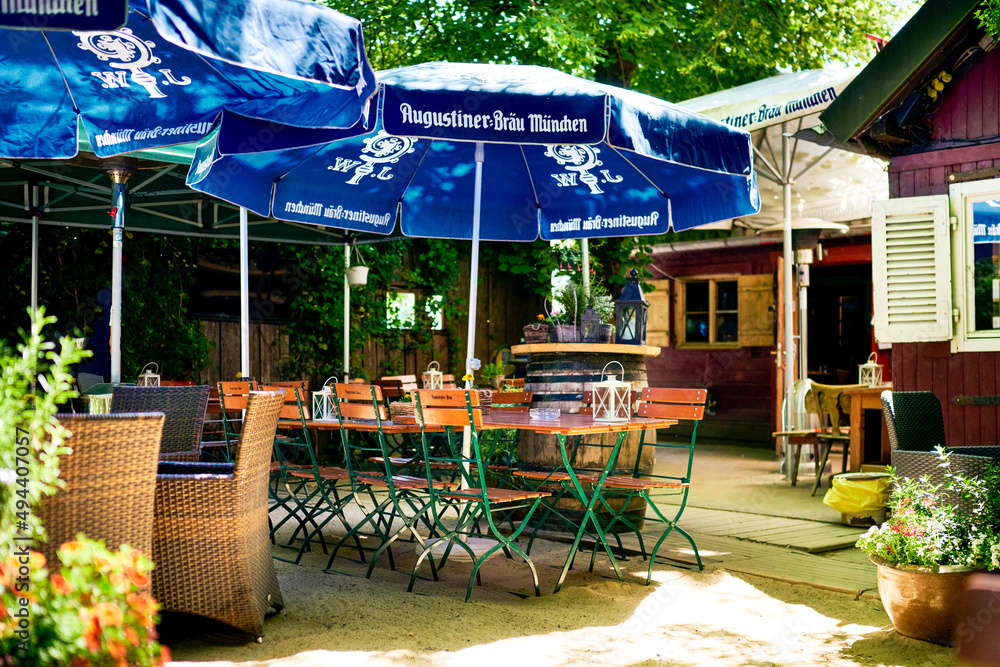 Wunderschöner Augustiner Biergarten in Bayern mit tollen Biertischen und Schirmen in der Natur mit Pflanzen Stock-foto