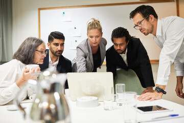 Business people look intently at monitor from laptop