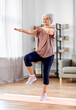 © Syda Productions - sport, fitness and healthy lifestyle concept - smiling senior woman exercising on mat at home