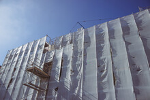 Building With Scaffolding Against The Blue Sky. Renovation Concept. Superbonus 110 In Italy.