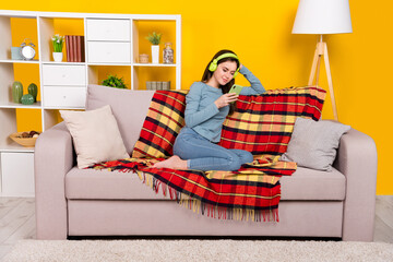 Sticker - Full size photo of positive peaceful lady sit barefoot couch use telephone isolated on yellow color background