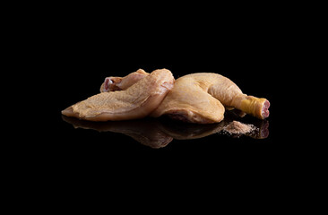 two chicken legs on a black glass plate