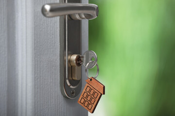 Wall Mural - Open door with key on blurred background, closeup