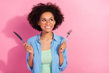 Wall Mural - Photo of dreamy inspired cute lady hold fork knife look empty space think lunch wear denim shirt isolated pink color background