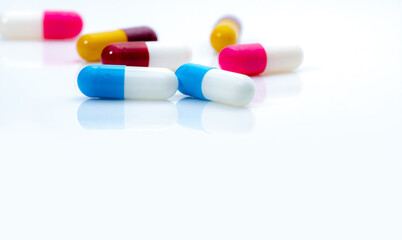 Canvas Print - Selective focus on blue-white antibiotic capsule pills on white background. Prescription drugs. Colorful capsule pills. Antibiotic drug resistance concept. Pharmaceutical industry. Superbug problems.