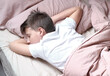 © lelechka - Boy teen sleeping on the bed in morning. Beds blanket is in light pink colors