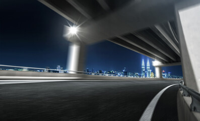 Motion blur effect highway overpass with city skyline background. Night scene .