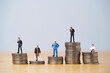 Five Miniature figure in each career standing to different high and low coins stacking for variation of income or salary in each job concept.