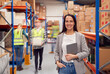 © Monkey Business - Portrait Of Female Manager With Digital Tablet In Busy Modern Warehouse With Staff In Background
