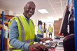© Monkey Business - Portrait Of Male Worker In Busy Modern Warehouse Working On Computer Terminal