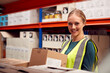 © Monkey Business - Portrait Of Female Worker Picking Box From Shelf Inside Warehouse