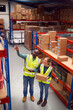© Monkey Business - Male Team Leader With Digital Tablet In Warehouse Training Intern Standing By Shelves