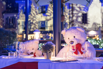 Poster - Cute  shot of two white plushie bears with red bows sitting around a Christmas table