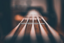 Closeup Shot Of A Bass Guitar Strings Against A Blurred Background
