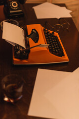 Sticker - high angle view of typewriter machine near papers and glass of whiskey.