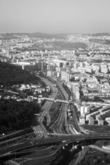 Canvas Print - Vertical grayscale drone shot of highways next to a cityscape.