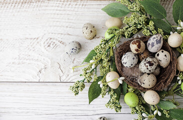 Wall Mural - green wreath with easter quail eggs and flowers on wooden background