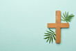 Palm branches and cross on color background, top view. Palm Sunday concept
