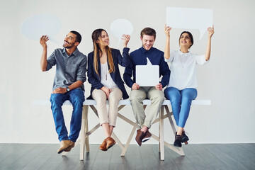 Poster - We are entitled to our opinion. Shot of a diverse group of creative employees holding up speech bubbles inside.