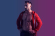 © A Stock Studio - Strong athletic male bodybuilder looking away. Blue violet lighting color. Banner for advertising a fitness center or gym.