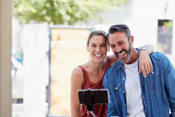 Sticker - Caption Newlyweds. Cropped shot of an affectionate couple taking a selfie together with a selfie stick outdoors.