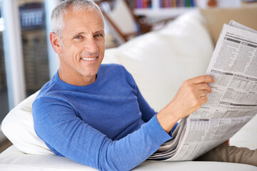 Poster - Catching up on the news. Portrait of a happy mature man reading the newspaper.