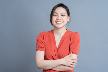 Wall Mural - Young Asian woman posing on gray background