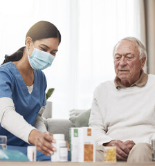 How many of these do you take. Shot of a young female nurse helping a patient with their medication during a checkup at home.