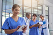 © Lucinda De Bruin/peopleimages.com - Theyre making some groundbreaking medical discoveries. Cropped shot of a medical practitioner looking at a patients file on a digital tablet with colleagues in the background.