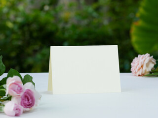 Mockup white blank space card, for Name place, Folded, greeting, invitation on wedding table setting background. with clipping path