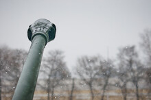 The Barrel Of An Artillery Gun During A Snowfall. The Contours Of Trees Are Blurred In The Background. Snowflakes Are Falling. Copy Space. Selective Focus.