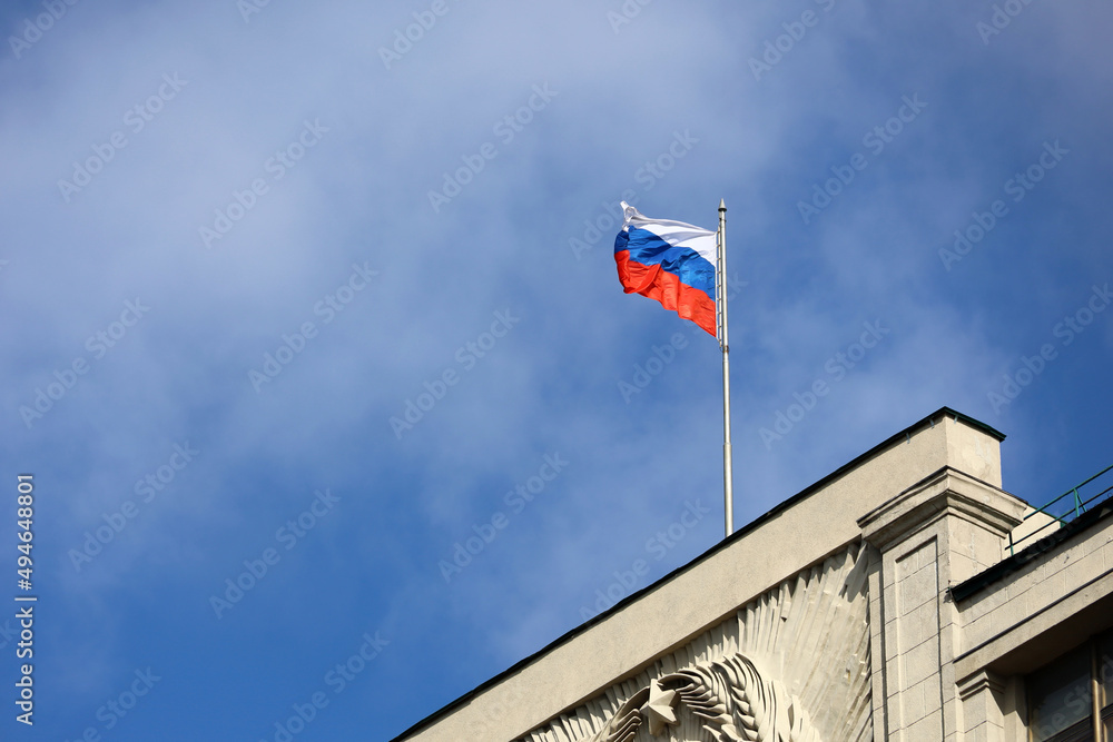 A view of the Russian parliament building in Moscow with flags flying.