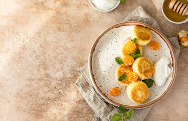 Wall Mural - Curd or ricotta fritters with physalis, honey, yogurt and mint on plate. Cottage cheese pancakes or syrniki. Healthy and tasty breakfast. Top view.