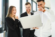 © Andrii  - Office staff laughing while looking at a laptop