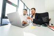 © Andrii  - Two multiracial male office workers working on a laptop. IT company employees