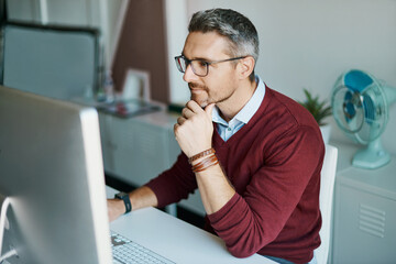 Giving some thought to his innovative ideas. Shot of a mature businessman working on a computer in an office.