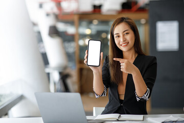 Beautiful young Asian businesswoman happy holding and presenting smartphone blank screen isolated on white background, businesswoman confident showing phone screen empty, advertising concept.